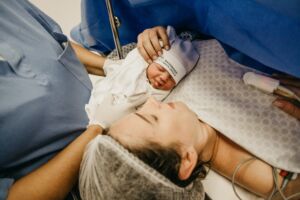 baby beside woman after a cesarean birth