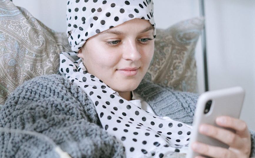 woman in bed using her smartphone