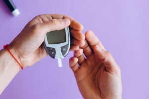Person holding a glucose meter, preparing to check blood sugar levels