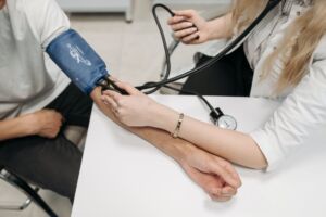 Image of a person taking manual blood pressure measurement.