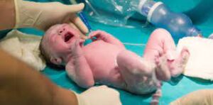 Healthcare professional conducting initial examination on a newborn baby
