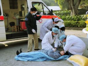 Person receiving emergency treatment from medical personnel outside