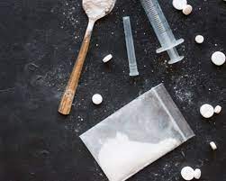 Spoon, sachet of powder, spoon, and tablets on display on the countertop: Substance abuse