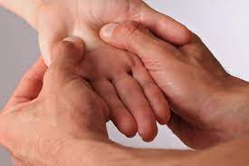 Person applying acupressure to the hand