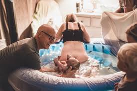 Partner holding baby after VBAC waterbirth