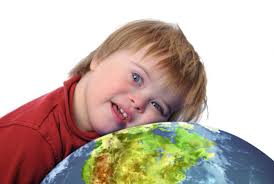 Young child leaning over a globe, representing global awareness and inclusivity for individuals with Down Syndrome.