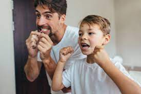 Teaching oral care: Father and son engaging in dental hygiene routine.