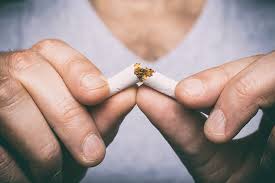 Person breaking a cigarette in half - Symbolizing the determination to quit smoking for a healthier lifestyle and well-being.