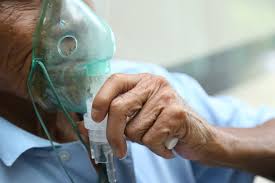 Individual undergoing nebulization therapy for respiratory relief from COPD.