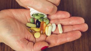 Person pouring supplements into their palm - showcasing the importance of integrating supplements into daily health practices