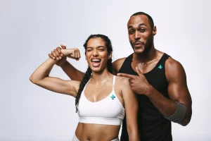 Woman and her personal trainer smiling during a successful exercise session.