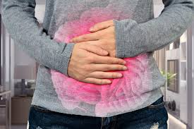 Person holding abdomen in IBS pain - Understanding symptoms and discomfort in Irritable Bowel Syndrome