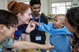 Image showcasing a child joyfully engaging with healthcare professionals, emphasizing the importance of a healthy and positive connection with medical care.