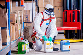 Person in hazmat suit handling chemicals: Workplace safety precautions