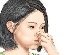 woman holding her breath while pinching her nose - Equalizing Ear Pressure