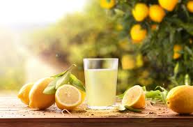 Lemons beside a glass of lemon juice - Citrus Refreshment