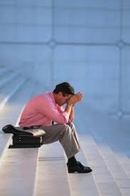 Person seated on steps with head in hands, reflecting on substance use