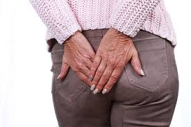 Person standing, blocking buttocks due to hemorrhoids discomfort