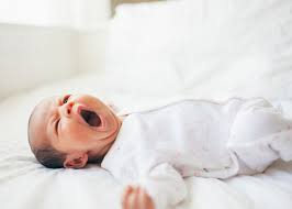 Adorable baby yawning, showcasing natural night sleepers behavior.