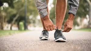 Person tying shoelace before exercise routine