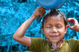 Child pouring water over their head: Cooling off during a heatwave.