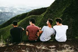 Group of friends exploring nature, sitting on a mountain, emphasizing outdoor activities 