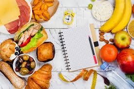  Assorted food items spread out on the table with a notepad - Illustration showcasing meal planning for intermittent fasting, with various food items arranged on a table next to a notepad