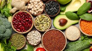 Nutrient-rich superfoods including fruits and vegetables, including avocado and beans, arranged on a table, promoting cardiovascular wellness through wholesome choices.