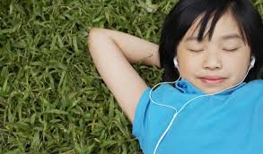 Person laying on the ground with earphones in ears