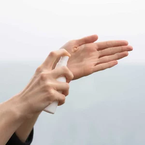 Person spraying hand sanitizer in their hand: Practicing effective hand hygiene with sanitizer.