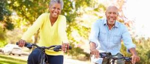 Happy elderly couple enjoying a bicycle ride together: green tea can help boost metabolism