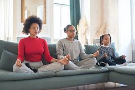 Mother and daughters meditating on the couch. A serene moment of family mindfulness to mentally refresh together.