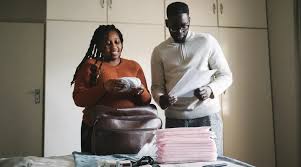 Birth plan: Couple packing for the hospital - An image showing a couple carefully preparing and organizing essential items for their upcoming hospital stay as they eagerly anticipate the arrival of their baby.