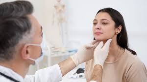 Doctor palpating the patient's neck during a medical examination.