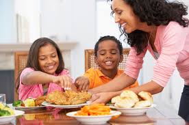 Family enjoying a meal together, emphasizing safe food handling practices