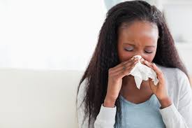 Woman sneezing into a tissue to prevent the spread of germs
