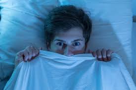 Scared person lifting bedsheet over their head 