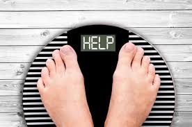 Person standing on a scale with 'HELP' written over the gauge, highlighting the plea for assistance in overcoming weight-related challenges.