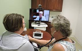 Telemedicine appointment: Woman consulting healthcare provider, caregiver monitoring vitals