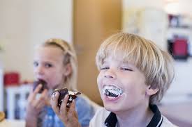 Kids enjoying a sweet treat with smiles and delight of sugar consumption