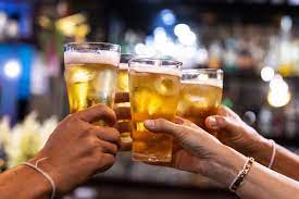 Joyful friends raising their beer glasses in a responsible toast.