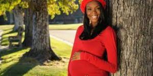 Pregnant woman embracing a healthy pregnancy, resting on a tree, showcasing the beauty of maternal well-being and the effects of maintaining a healthy diet