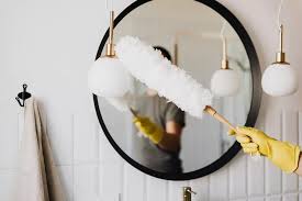 Person dusting home to remove allergens for a cleaner and healthier environment.