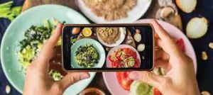 Person capturing the essence of healthy foods through a lens, emphasizing the role of mindful choices and nutrition in the pursuit of sustainable lifestyle changes for a healthier lifestyle.