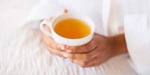 Person holding a teacup, savoring the soothing and healthful delights of this ancient beverage.