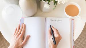 Person writing on a journal. Find solace and mental refreshment through the therapeutic act of journaling and self-reflection.