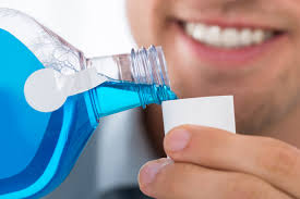 Man pouring mouthwash - Incorporating mouthwash for comprehensive oral care.