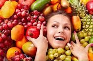 Person amidst a variety of fruits and vegetables, emphasizing those rich in Vitamin C.