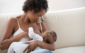 Woman tenderly nurturing her baby, capturing the intimate and nurturing connection between mother and child 