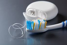 Toothbrush next to a tube of dental floss. Essential tools for optimal dental health.